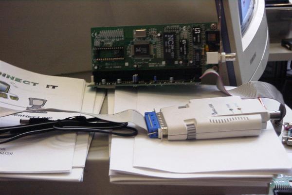 Bild: Der graue Kasten im Vordergrund ist
der Genius-LAN-Adapter, der mittels des Parallelport-Interfaces für den
ROM-Port von Elmar Hilgart an den ROM-Port eines Ataris angeschlossen wird. Das Teil im Hintergrund auf dem Bild ist der ACSI-Ethernet-Adapter.